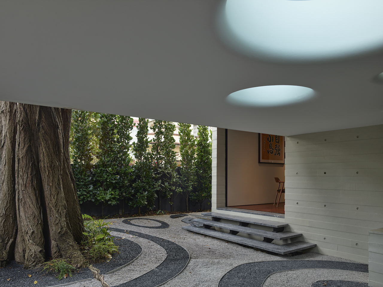 The design team detailed the ceiling of the canopy around the tree to reflect the concentric circles on the pebbled ground.