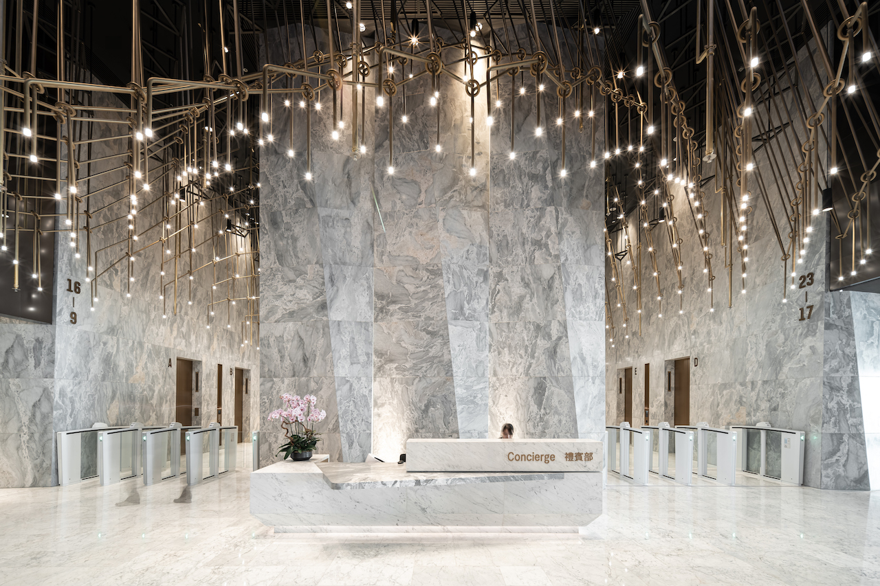 An imposing lobby clad in precision-cut stone; a material that was also used to create the minimally designed concierge reception desk and its arresting backdrop.
