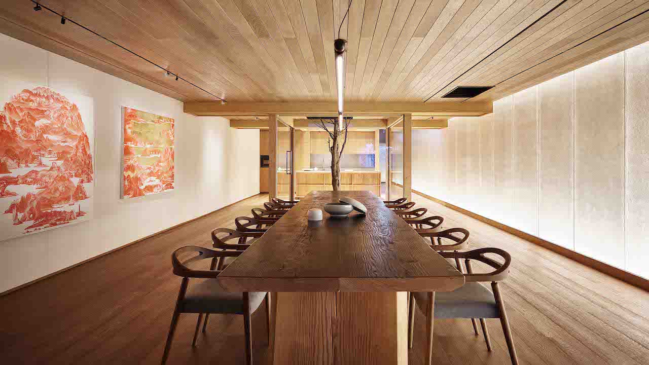 The dining banquet room is adorned with vibrant Korean artworks.