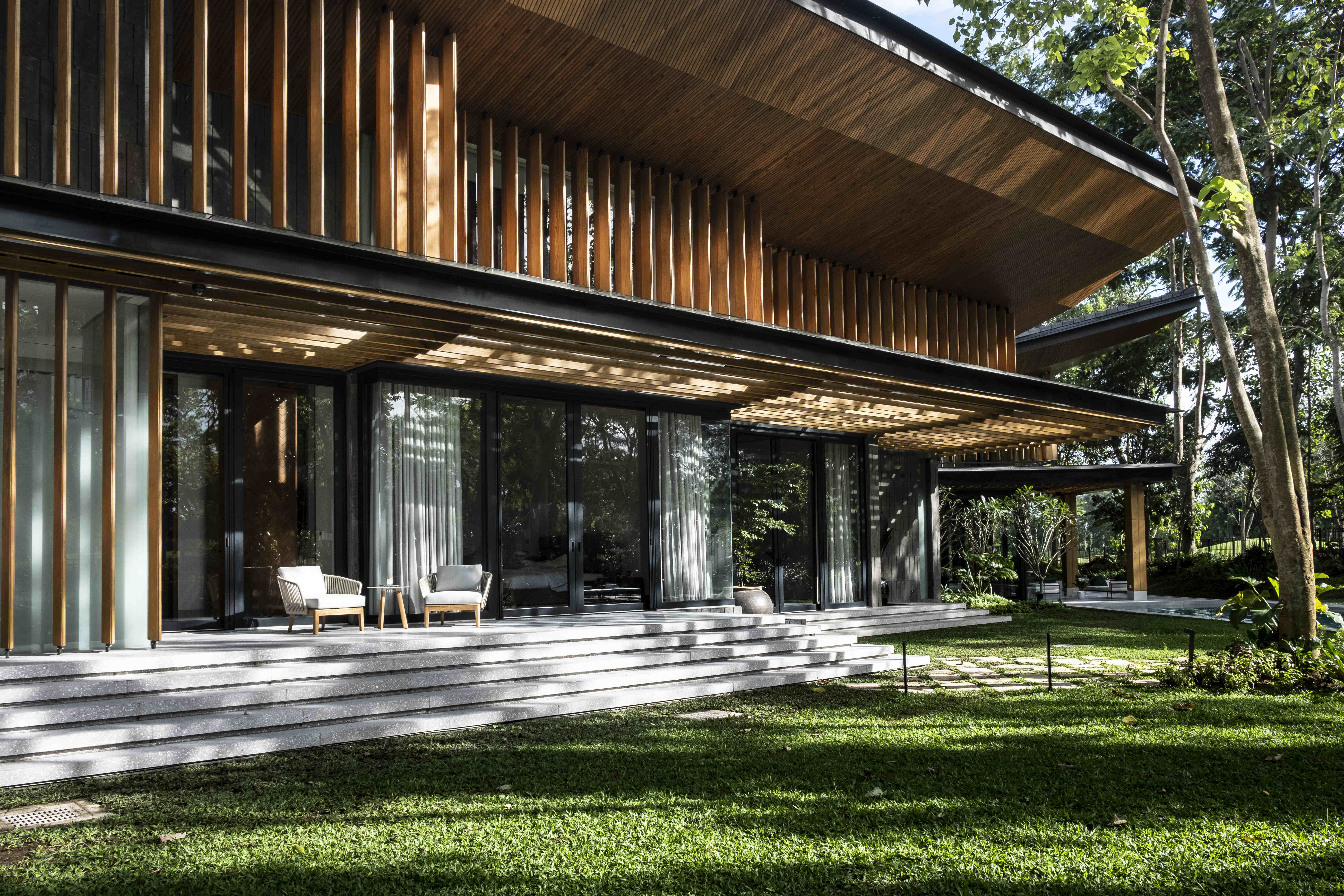 The series of vertical and horizontal brise soleil installed into the structure works with the mature trees that are flourishing within the vicinity