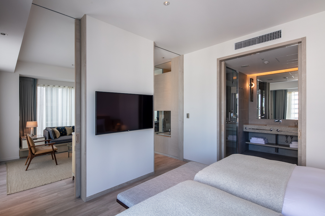 The suite boasts large sliding doors that separate the living/dining spaces and bedroom/bathroom.